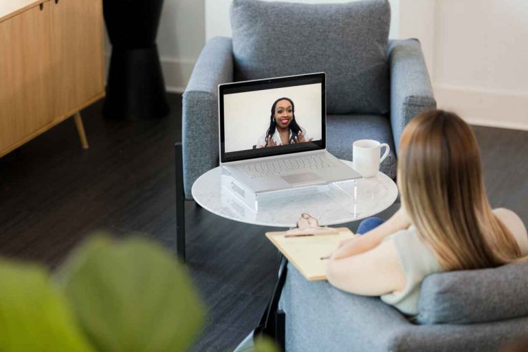A therapist providing video counseling to a client in an office